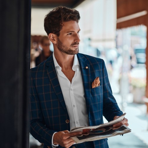 A man in a blue suit and white shirt holding a newspaper